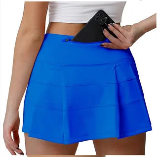 Rear waist zip pocket on a blue pleated sports skort shown with a phone to illustrate storage